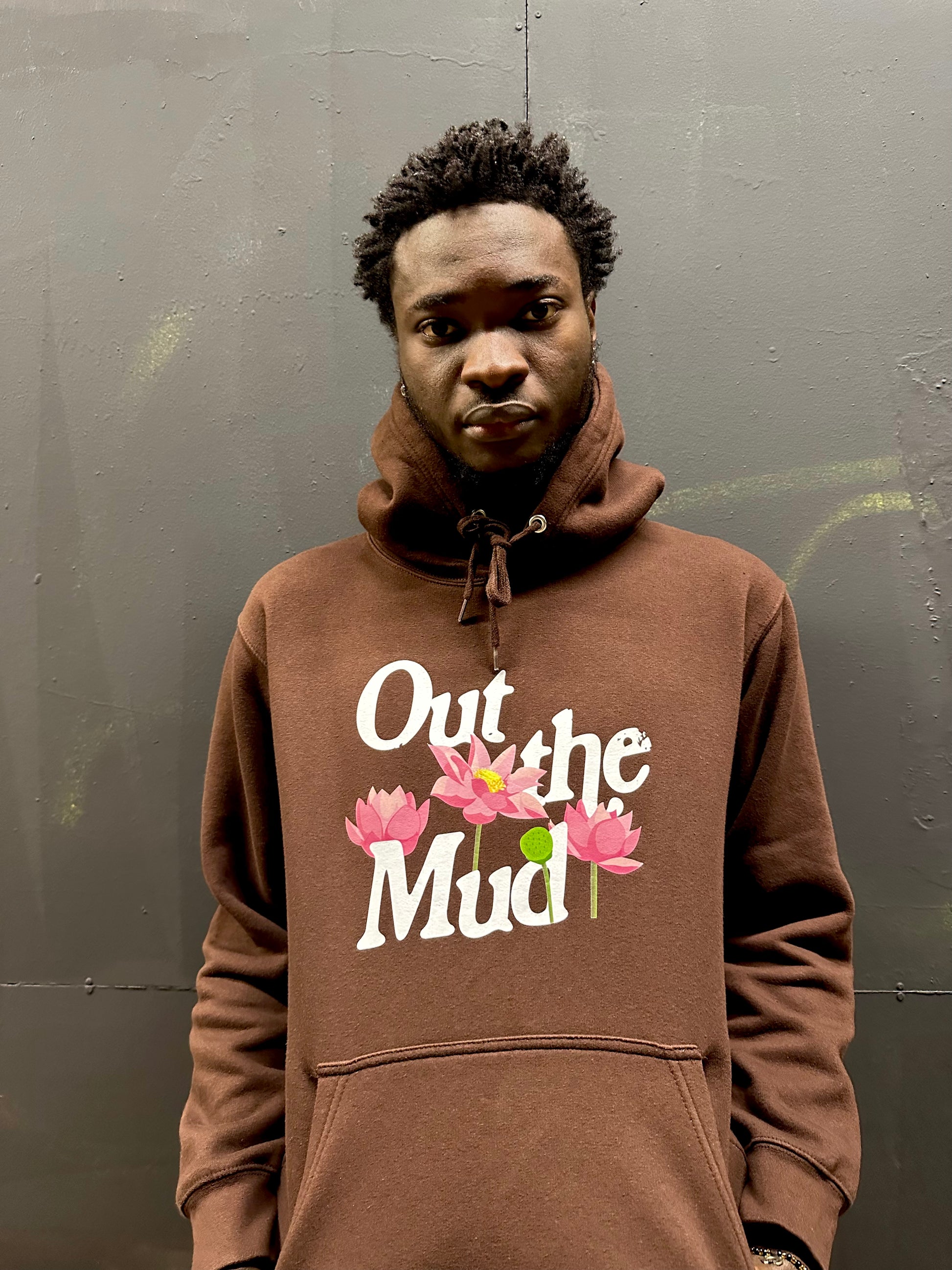 man wearing brown pullover hoodie with out the mud lotus flower design