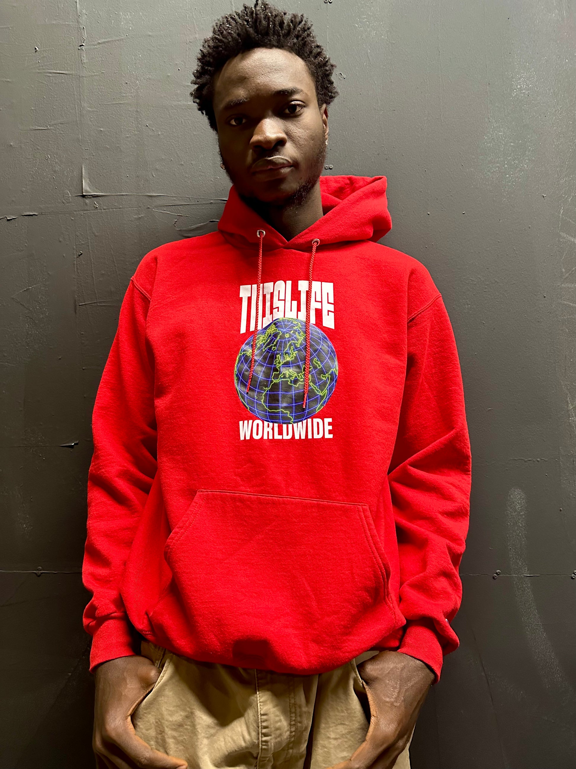 man wearing red champion pullover hoodie with THisLIFE Worldwide design